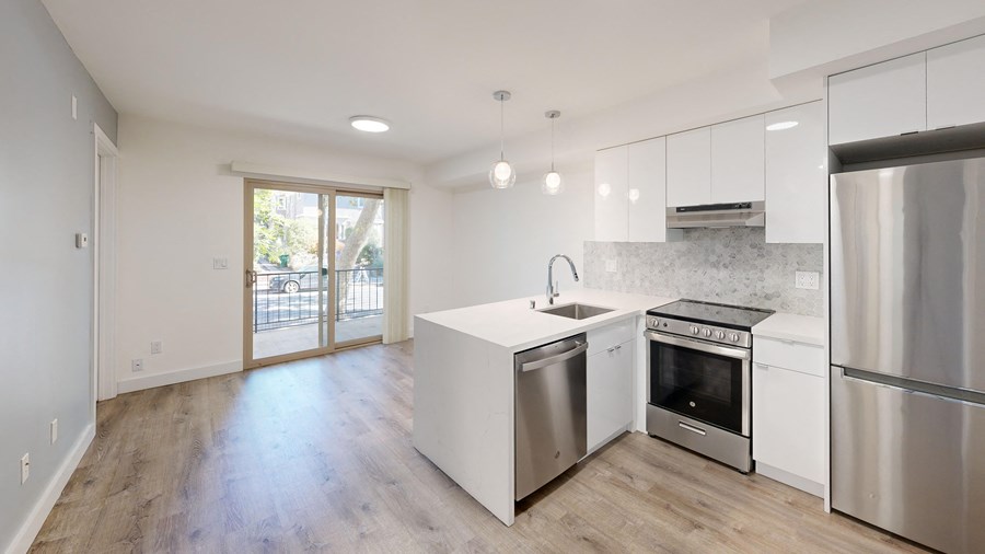 a renovated kitchen with white cabinets and stainless steel appliances
